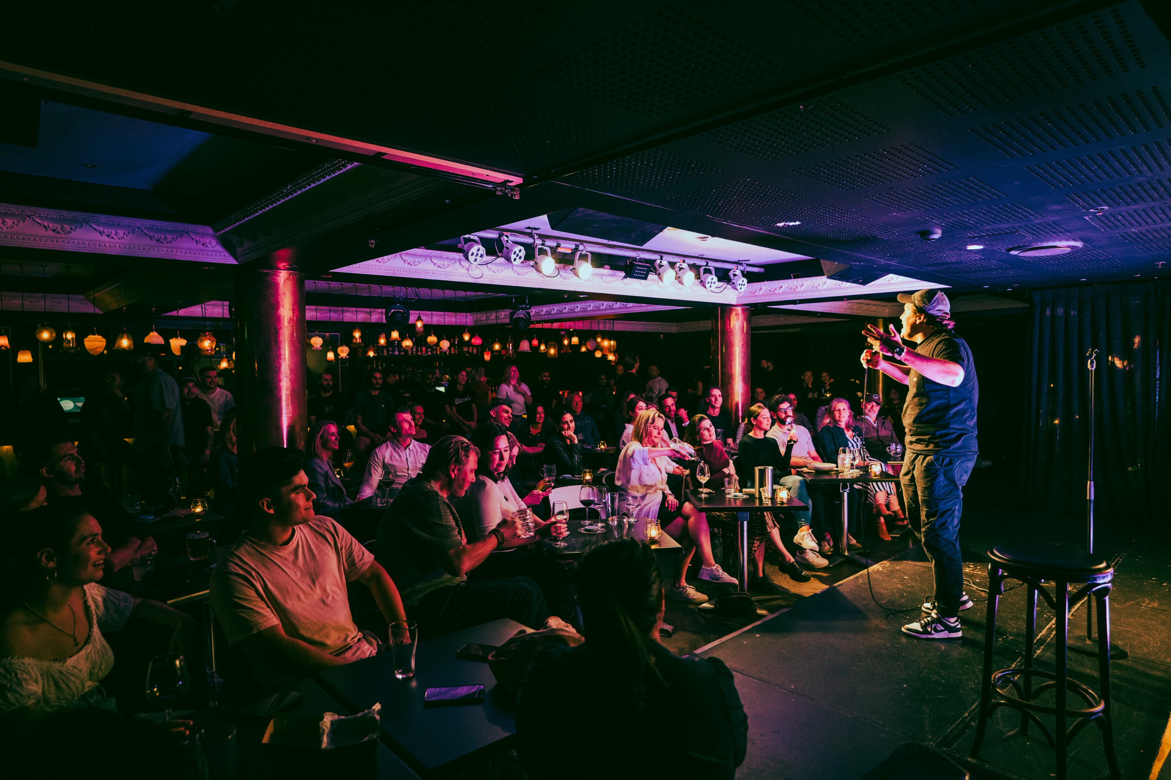 A comedian working a packed row of tables