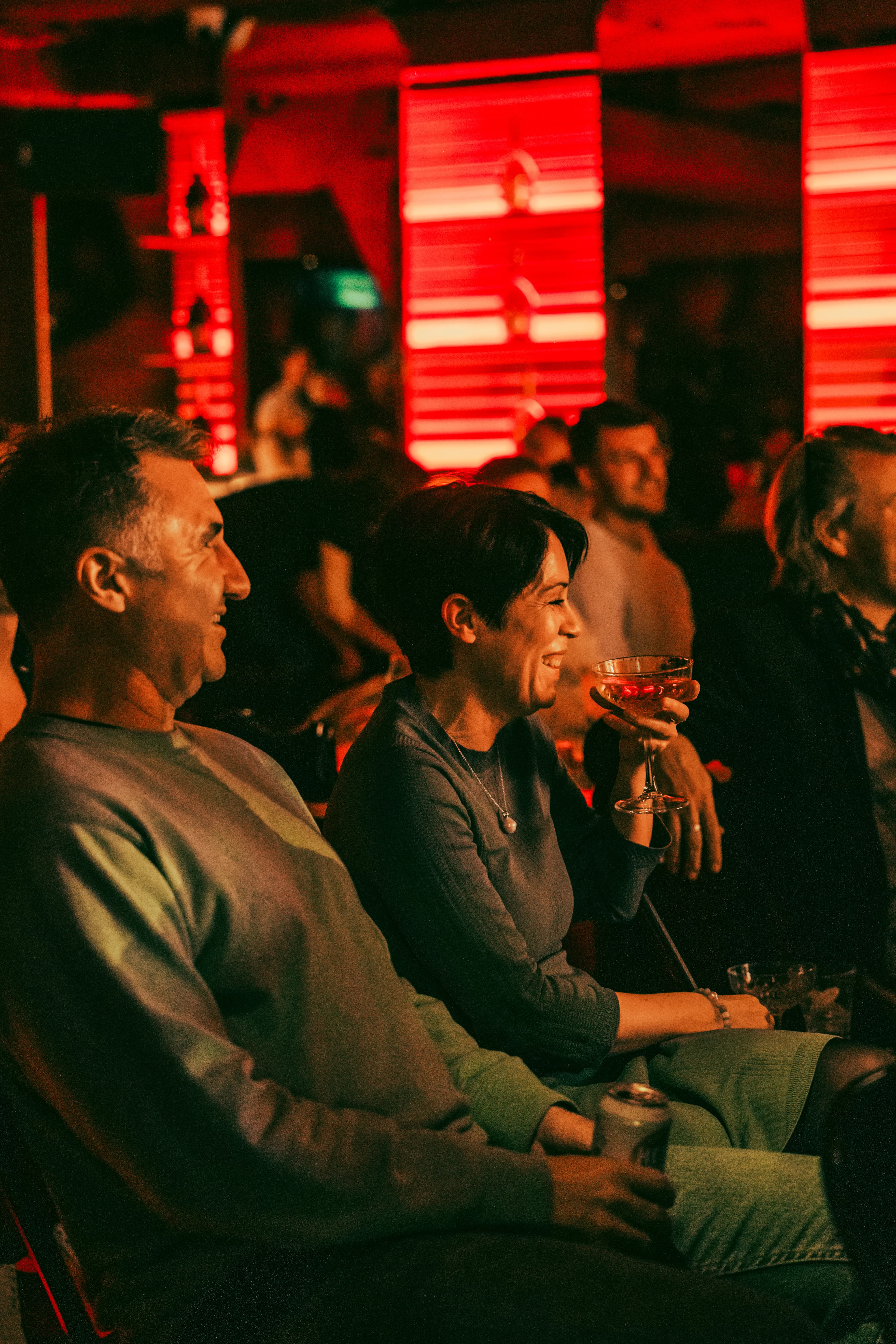 Two audience members laughing over drinks