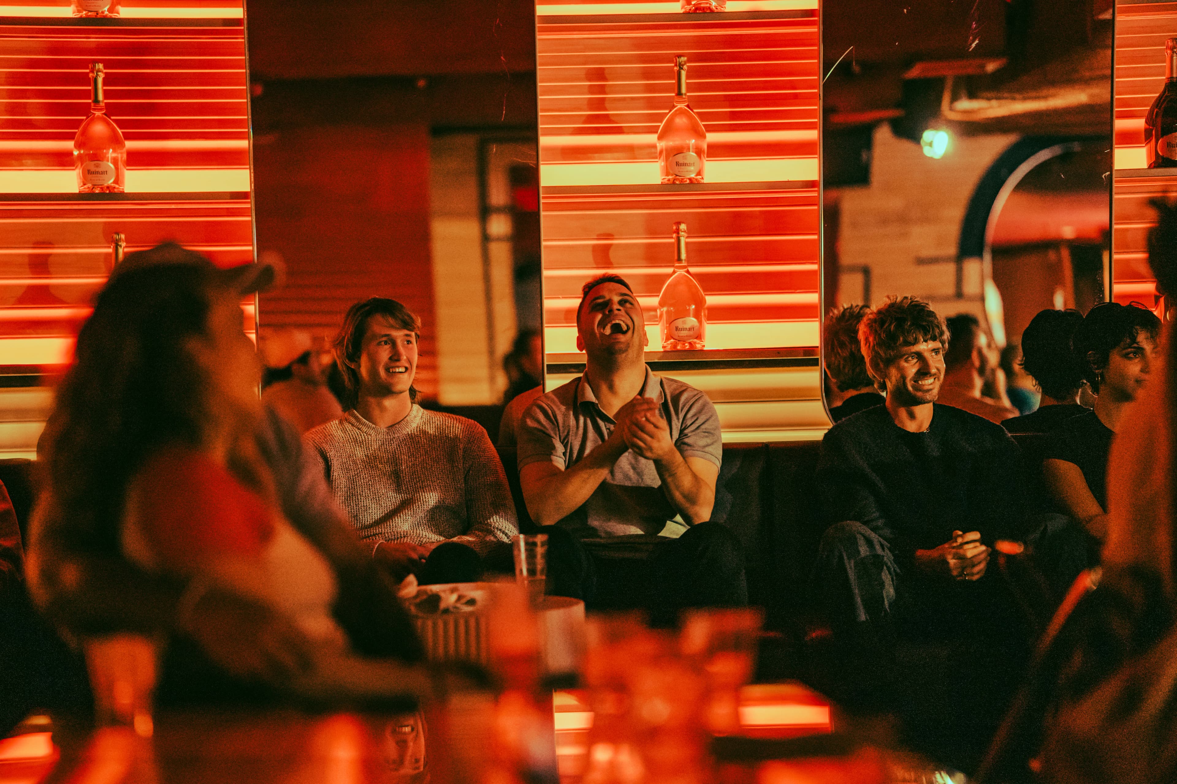A packed comedy-night crowd mid-laugh